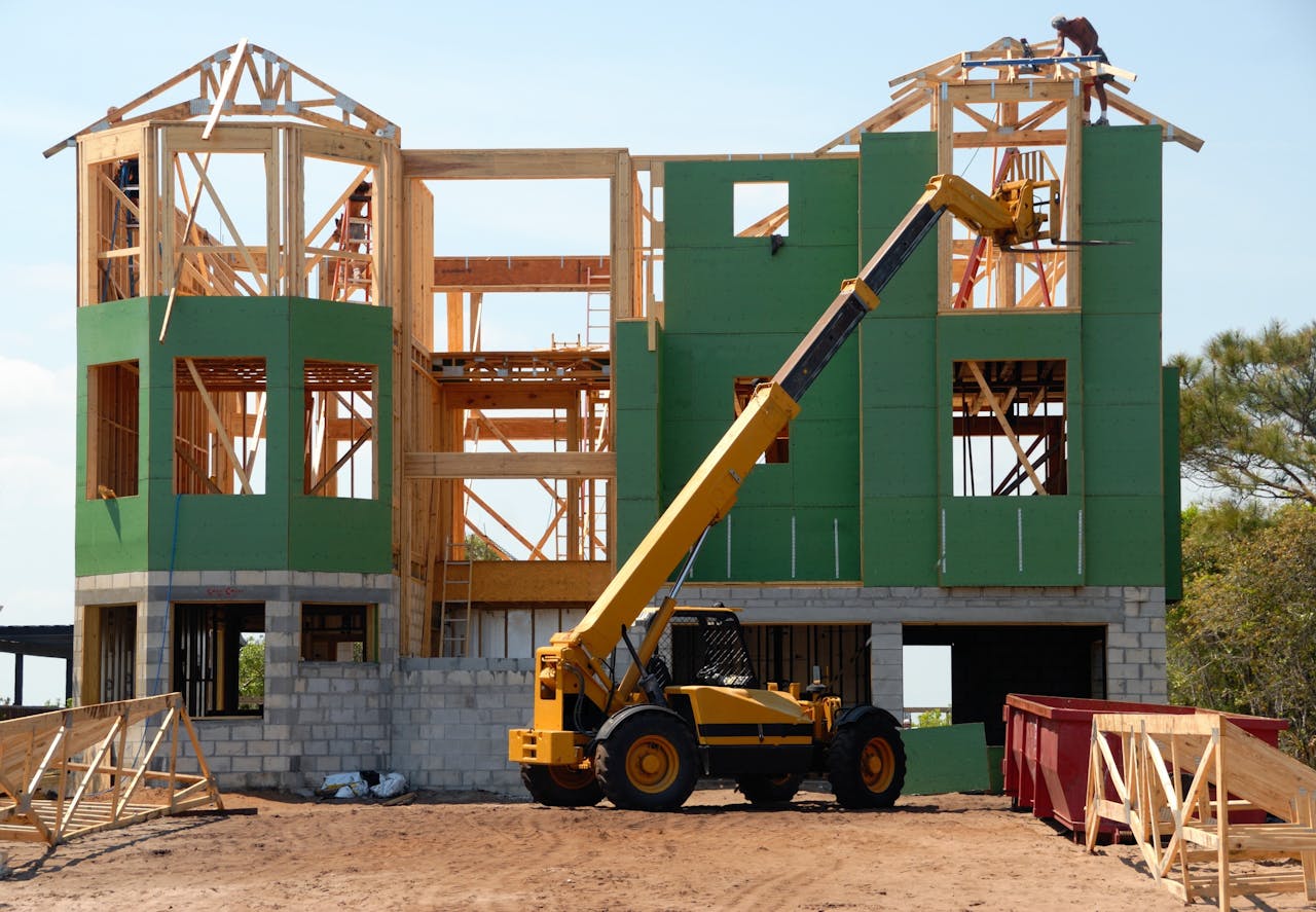 story-01 A multi-story wooden house under construction using a crane on a sunny day.