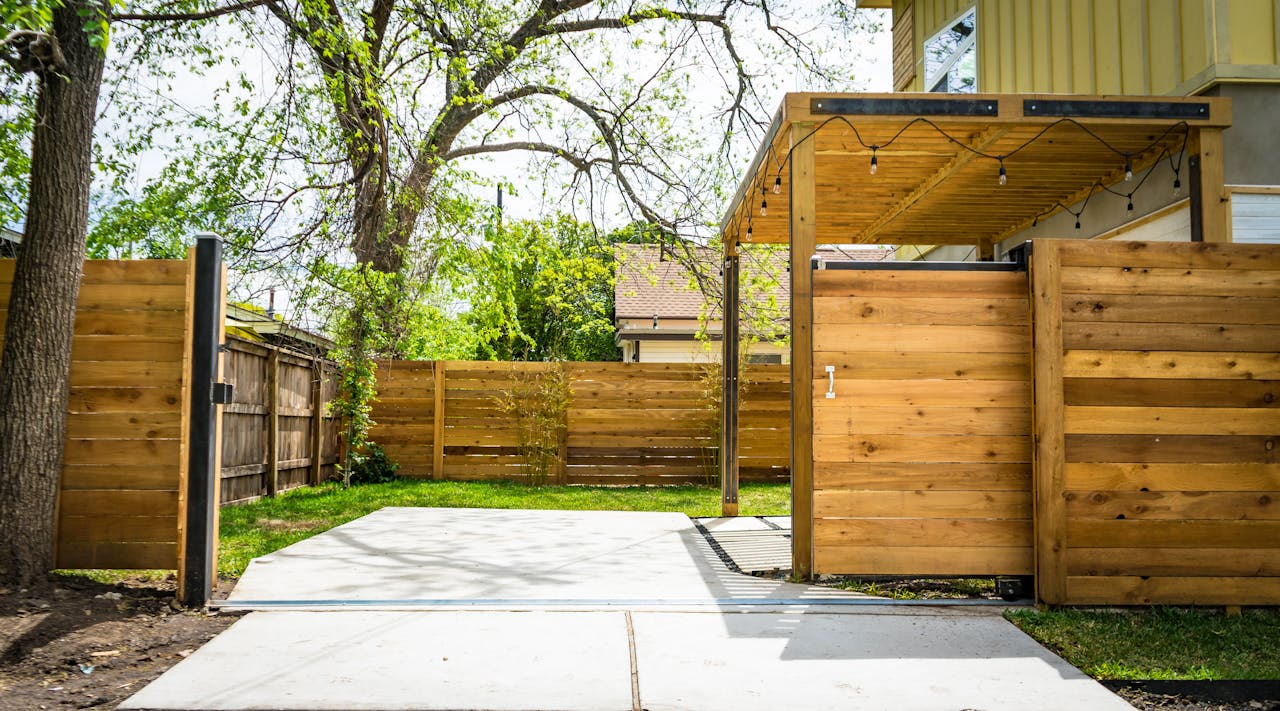 story-02 Sunlit wooden fence and patio gate in a peaceful backyard setting.